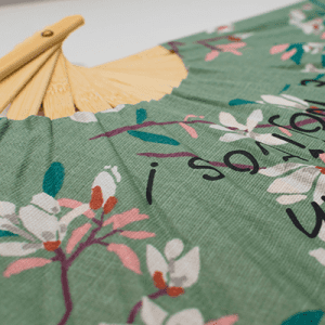 Un tissu vert avec des fleurs roses.