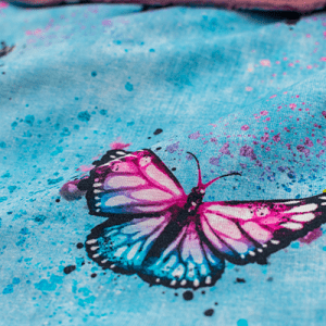 Un tissu bleu avec un papillon violet.